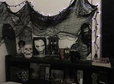 there is a shelf with books and pictures on it in front of a wall decorated with halloween decorations