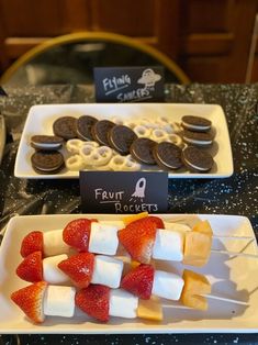 desserts are displayed on white trays at a party