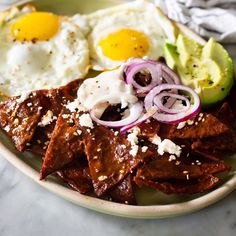 a plate with meat, eggs and onions on it