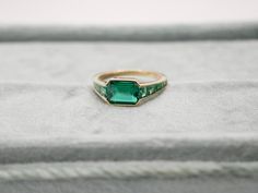 At the centerpiece of this lab grown Zambian emerald ring is a radiant 1.5 ct emerald, set east west to highlight its natural allure. Flanking it are calibre cut emeralds, each uniquely shaped to create a seamless gradient effect, making every ring truly one-of-a-kind. Set in luxurious 18K yellow gold, this ring exudes timeless charm. What makes it truly special? Calibre cut stones are individually shaped to fit precisely into the design, resulting in a mesmerizing display of color and brillianc Emerald Set, Zambian Emerald, Step Cut, Brooch Jewelry, East West, Emerald Ring, Ring Bracelet, Lab Grown, Ring Earrings