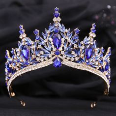 a tiara with blue and white stones on it's headpiece, sitting on a black cloth