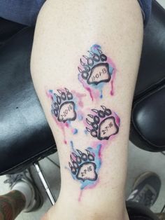 a person with a tattoo on their leg that has three paw prints painted on it