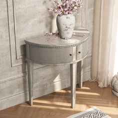 a white vase with flowers sitting on top of a table next to a rug and window