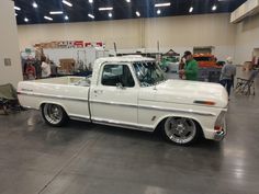 an old white pickup truck parked in a garage