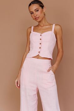 a woman wearing pink pants and a crop top