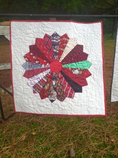 a quilted wall hanging on the side of a fence