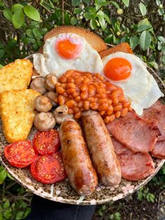 a plate with eggs, sausages, beans and tomatoes