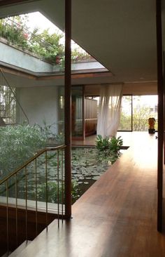 the inside of a house with water lilies and plants on the balcony railings