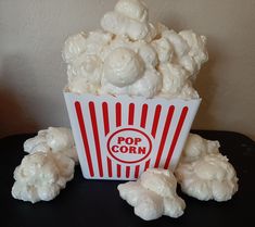 a popcorn bucket filled with marshmallows on top of a table