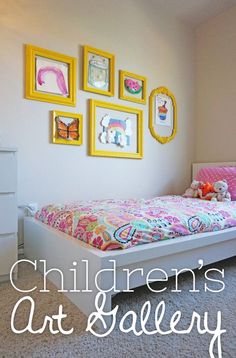 a child's bedroom with pictures on the wall and a bed in front of it