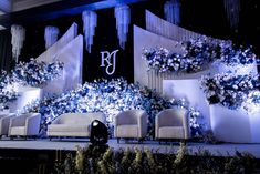 the stage is decorated with blue flowers and chandeliers