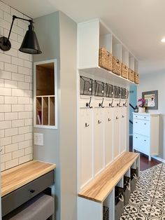 a room that has some benches and lights on the side of it with baskets hanging above them