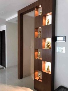 an empty room with some shelves and lights on the wall, in front of a door