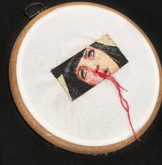 a close up of a embroidery on a piece of cloth with a needle in it