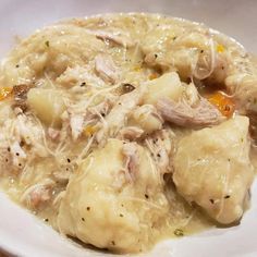 a white plate topped with dumplings covered in gravy