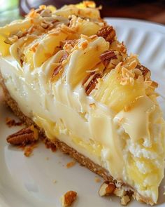 a piece of cheesecake on a white plate with pecans around the crust and toppings