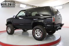 a black truck is parked in a showroom