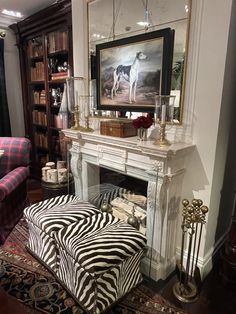 a living room filled with furniture and a fire place covered in zebra rugs next to a fireplace