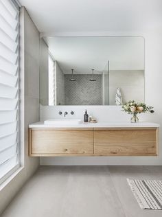 a bathroom with a sink, mirror and rug on the floor