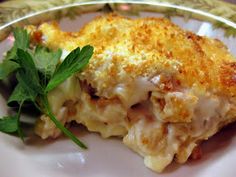 a white plate topped with an entree covered in cheese and garnished with parsley