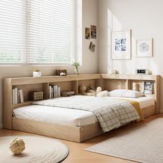 a bedroom with a bed, bookshelf and rugs on the hardwood floor