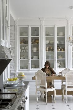 a woman sitting at a table in a kitchen