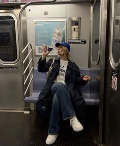 a woman sitting on a subway car drinking water