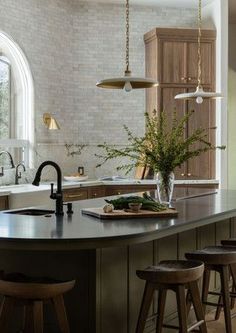 A spacious and stunning kitchen space with curved island and beautiful wood cabinetry.