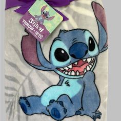 a blanket with stitch from the movie stitch and stitch on it, next to a tag