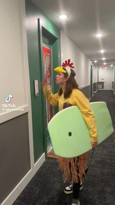 a person in a costume holding a surfboard and pointing at the door to another room