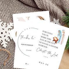 two christmas cards sitting on top of a table next to a snowflaked tree