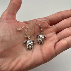 These adorable dainty turtle earrings are antique silver plated. They make a great gift for Women and Girls who like turtles!  Quick Specs:  + 1 pair of turtle earrings  + antique silver plated  + Ear hook/ear wires  ALL PURCHASES COME GIFT WRAPPED AND W/DISCOUNT CODES! Nickel-free Silver Turtle Jewelry, Antique Silver Earrings For Gift, Turtle Jewelry, Earrings Antique, Turtle Earrings, Great Gifts For Women, Earrings Minimalist, Antique Earrings, Ear Hook