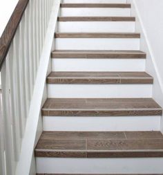 a set of stairs with wood treads and white handrailing in a home