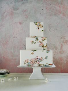 a three tiered cake with flowers painted on it