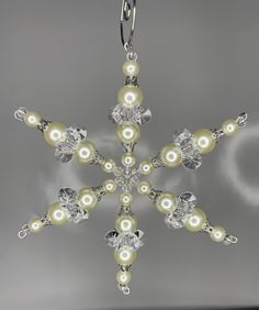 a snowflake made out of pearls and swarong crystals on a chain