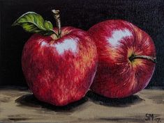 two red apples sitting side by side on a table