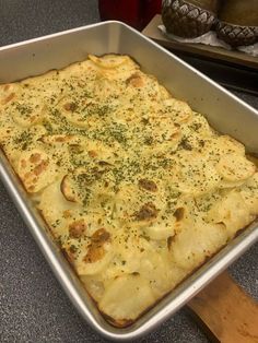 a square casserole dish with cheese and herbs