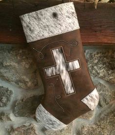 a brown and white stocking with a cross on it sitting on top of a stone wall