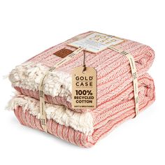 three red and white blankets stacked on top of each other with a tag that says gold case 100 % recycled