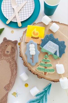 decorated cookies sitting on top of a wooden slice next to candles and other holiday decorations