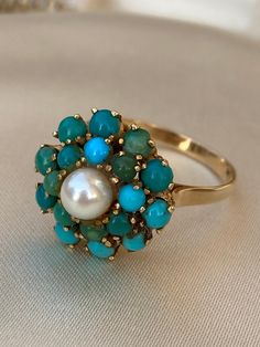 18ct Gold Natural Turquoise & Pearl Cluster Ring. Size P. This is a stunning ring, great statement piece. Hallmarked 18ct Central Pearl 5mm 18 natural turquoise stones 3cm total diameter Turquoise Multi-stone Ring For Gift, Fine Jewelry Turquoise Multi-stone Ring, Turquoise Multi-stone Ring Fine Jewelry, Gift Turquoise Cluster Ring With Gemstone, Elegant Turquoise Multi-stone Rings, Hallmarked Turquoise Ring Fine Jewelry, Hallmarked Turquoise Fine Jewelry Ring, Elegant Turquoise Ring With Natural Stones For Anniversary, Elegant Round Turquoise Ring With Natural Stones