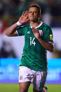 a man in green jersey holding his hand up