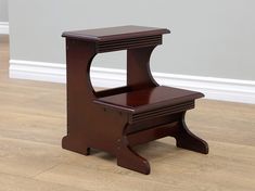 a small wooden step stool sitting on top of a hard wood floor