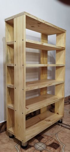 a wooden bookcase sitting on top of a tiled floor