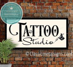 a sign that says tattoo studio next to a brick wall with a potted plant