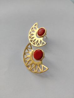 Beautiful and elegant Gold Stud Earrings with a pretty red coral stone (imitation stone). Details: Brass Gold Plated Hypoallergenic Handmade Stone earrings Lightweight *Care: Do not use perfumes or sanitizers around or on the jewelry. Clean it with a cotton cloth. **Gifting someone? Comes wrapped in eco-friendly wrapping paper with a beautiful handmade doodle card. (DM for reference) Red Brass Drop Earrings, Elegant Handmade Semi-circle Earrings, Red Chandbali Jewelry With Matching Earrings, Red Chandbali Jewelry For Gifts, Unique Red Earrings With Natural Stones, Red Brass Earrings For Wedding, Handmade Red Ruby Earrings, Elegant Semi-circle Brass Earrings, Fusion Style Red Drop Earrings