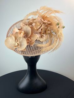 A beige woven saucer is artfully stacked with tan orchids and accented with tan peacock swords. Sits on a comfortable black headband. Ships in a high quality storage box. One of a kind.  Perfect for Kentucky Derby, Royal Ascot, church, weddings, just for fun. Luxury Beige Fascinator For Royal Ascot, Beige Fascinator For Royal Ascot, Beige Vintage Fascinator For Royal Ascot, Elegant Brown Adjustable Headpiece, Elegant Adjustable Brown Headpiece, Luxury Cream-colored Hat Headpiece, Elegant Luxury Flower-shaped Fascinator, Church Weddings, Green Orchid