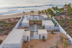 an aerial view of a beach house with solar panels on the roof and palm trees