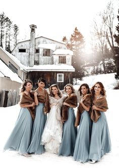 a group of women standing next to each other on top of a snow covered field