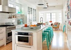 a kitchen with white walls and wooden floors has blue stools on the countertop